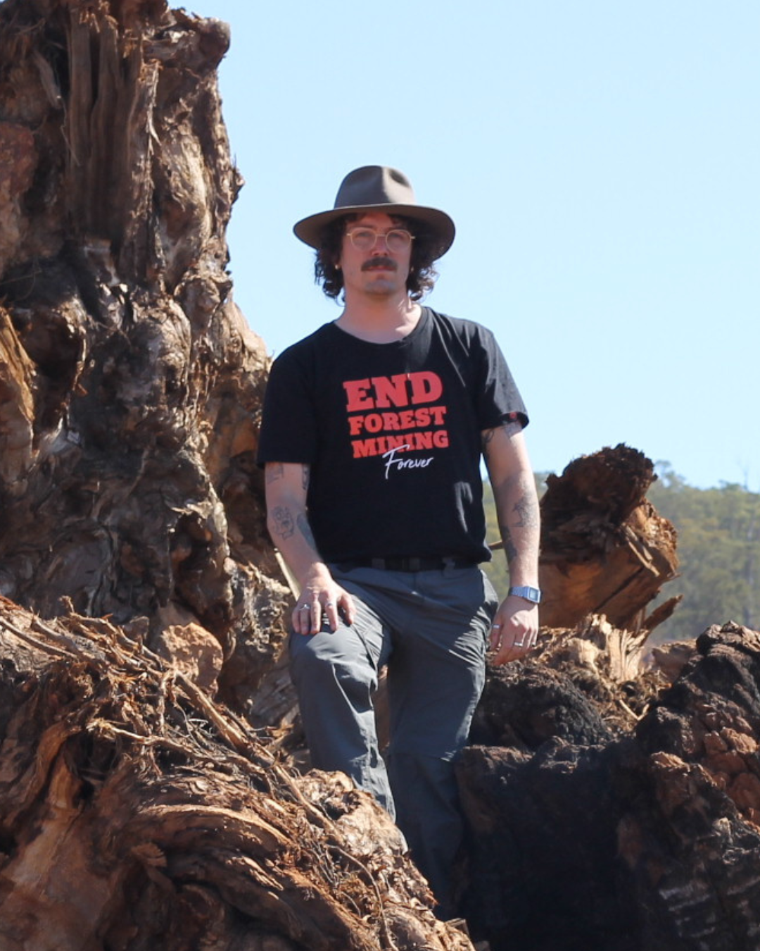Alex Saurin on a pile of logs at an Alcoa mine site.
